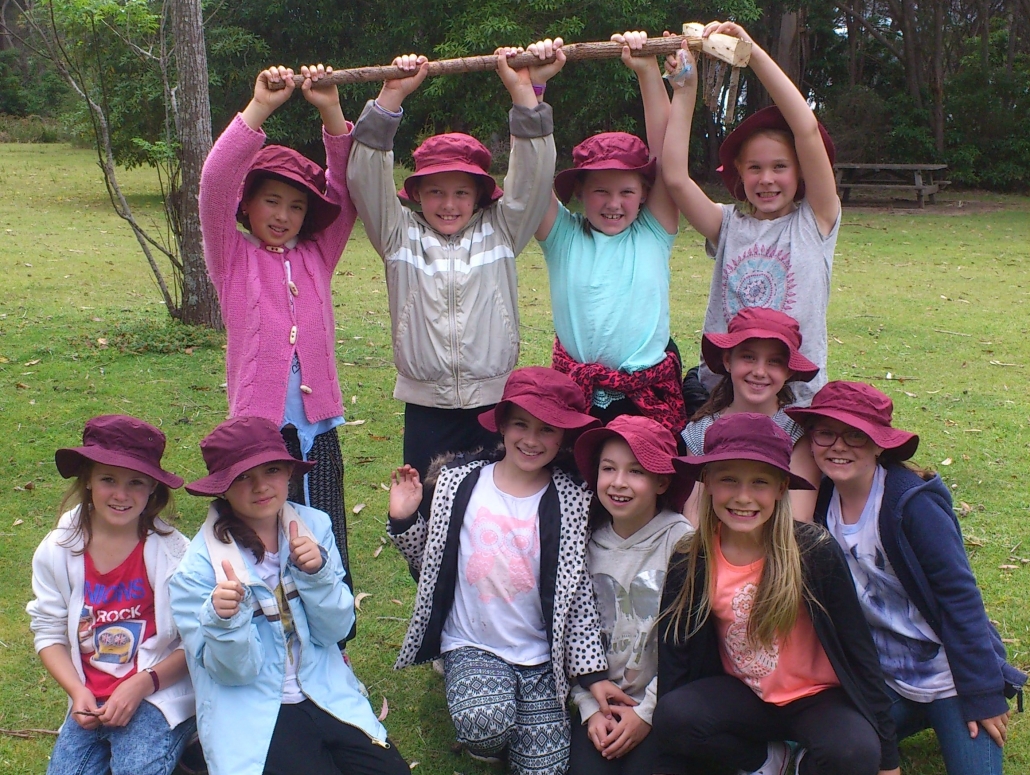 Tathra Public School students holding up a rake they have built by hand.