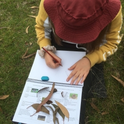 student writing in nature journal